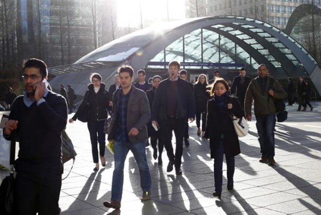 Workers leave the underground station at the Canary Wharf business district in London February 26, 2014. REUTERS/Eddie Keogh