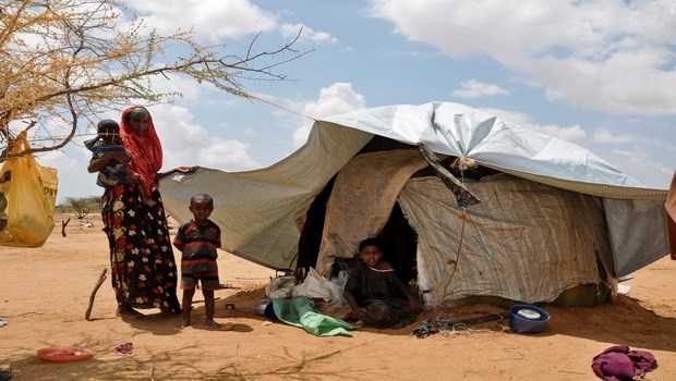 A newly arrived family of refugees from Somalia stand outside their shelter, near Dagahaley refugee camp, Dadaab, Kenya