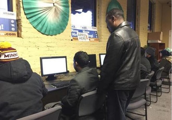 In this Dec. 20, 2016 photo, several people use self-help computers at an employment center in the heart of Minneapolis' largest Somali neighborhood. The center, which connects job seekers to employers, was created with grant money as part of a federal pilot project designed to combat terror recruitment by creating positive opportunities for youth. (AP Photo/Amy Forliti)