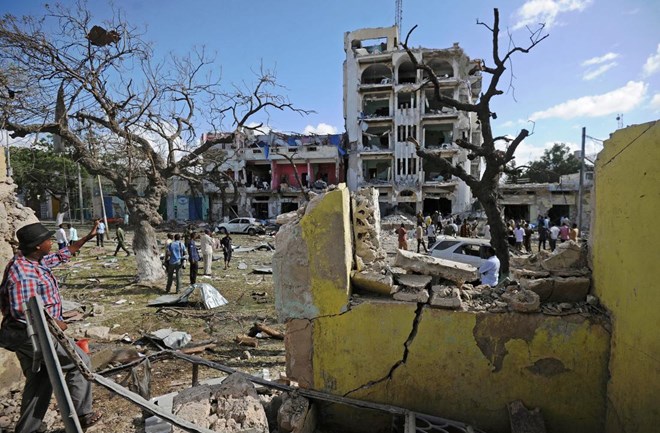 People stand on the scene of a terror attack outside The Ambassador Hotel in Mogadishu on June 2, 2016. (Mohamed Abdiwahab—AFP/Getty Images)