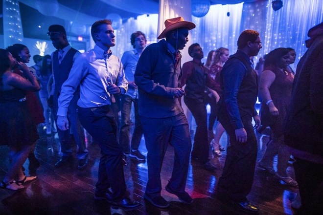 Mohamed Hassan, wearing a cowboy hat he had found at a photo booth, line-danced with fellow Roosevelt High School students at a school dance at the Profile Event Center in Minneapolis, Minn., on February 16, 2017. Renee Jones Schneider