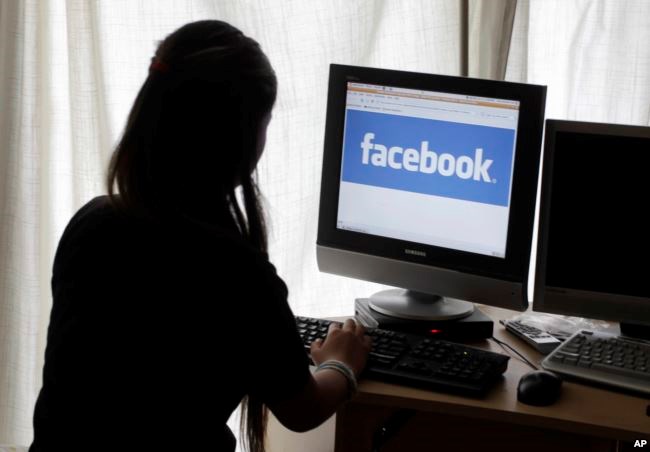 FILE - A girl looks at Facebook on her computer in Palo Alto, California.