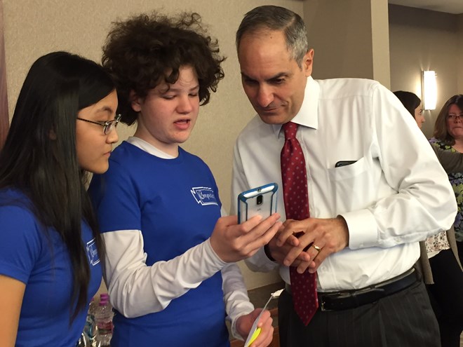 U.S. Bank CEO Andy Cecere checks out the financial app developed by teenage girls participating in Technovation. - Annie Baxter/marketplace